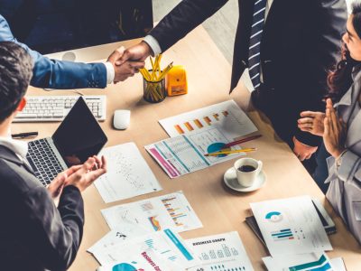 Group business people handshake at meeting table in office together with confident shot from top view . Young businessman and businesswoman workers express agreement of investment deal.